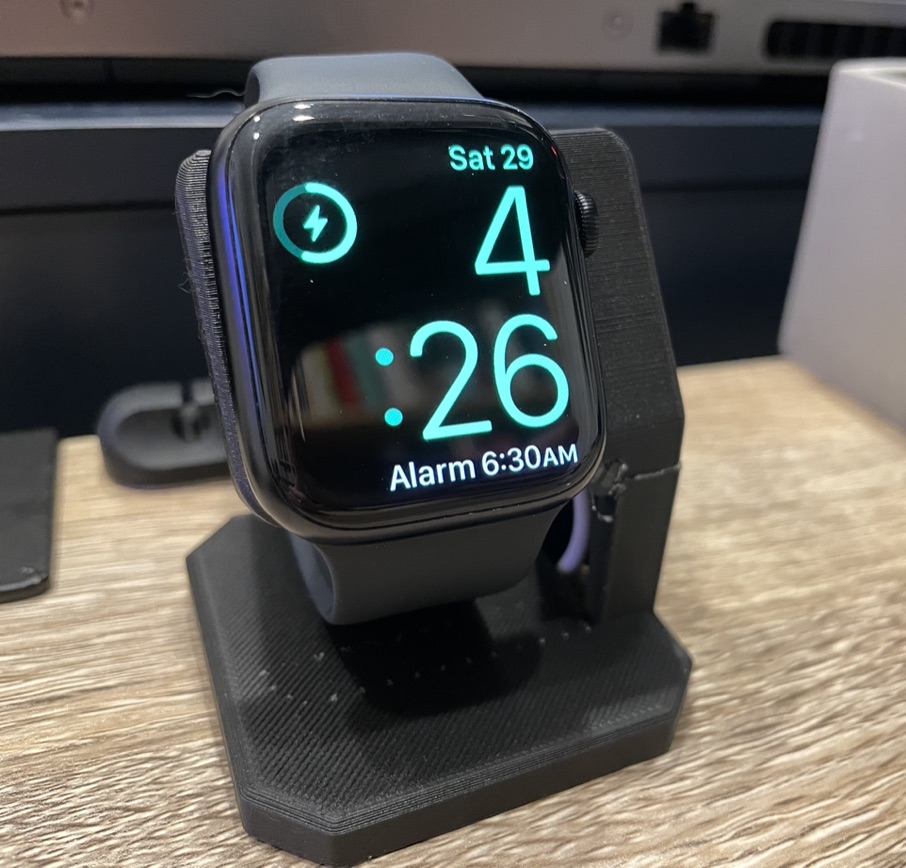 An Apple Watch on a 3D printed charging stand.