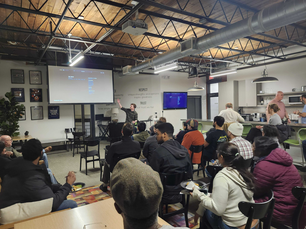 Me, in front of a crowd, gesturing up at a projector