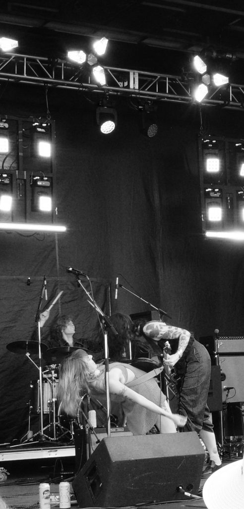 SKORTS, with a guitarist leaning over the basist