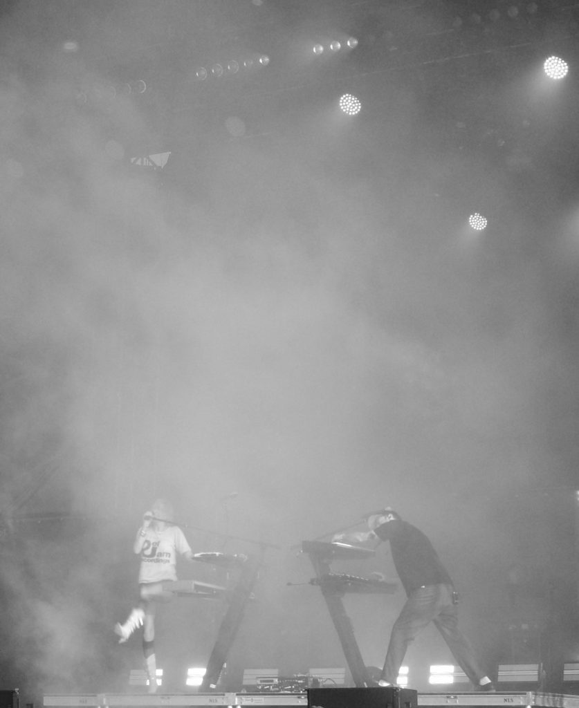 Phantogram, shrouded in fog, with Sarah doing a cool kick