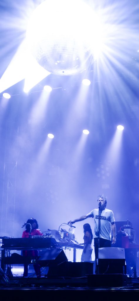 LCD Soundsystem, below their disco ball, with James kind of gesturing toward Nancy